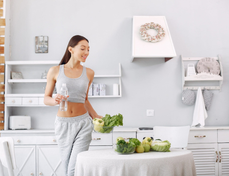Beautiful and sporty girl in a kitchen with a vegetables